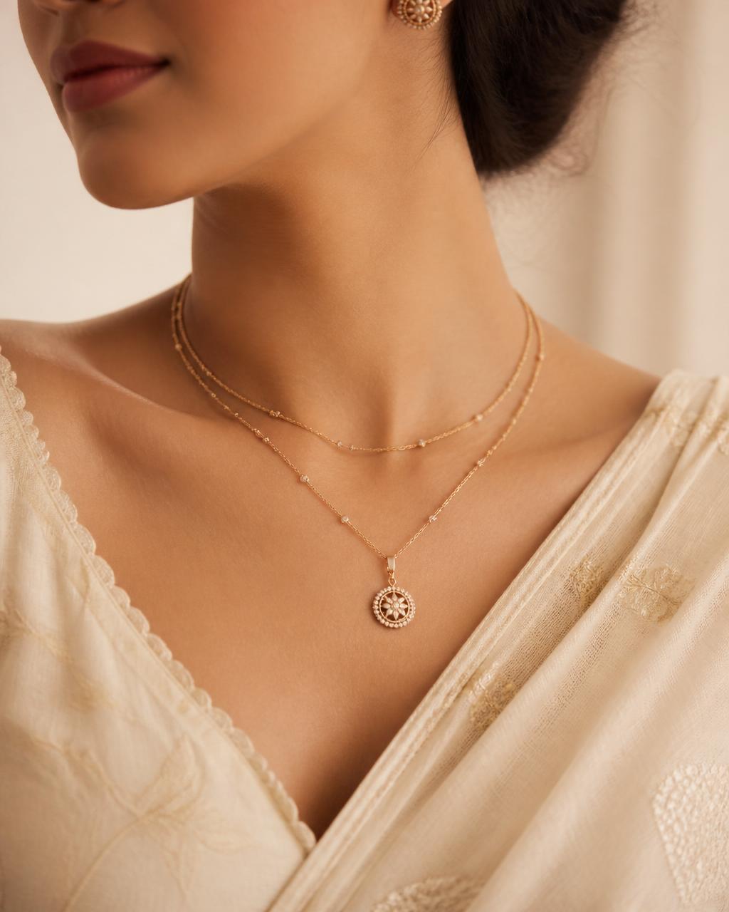 Woman wearing a delicate layered gold necklace over an ivory kurta